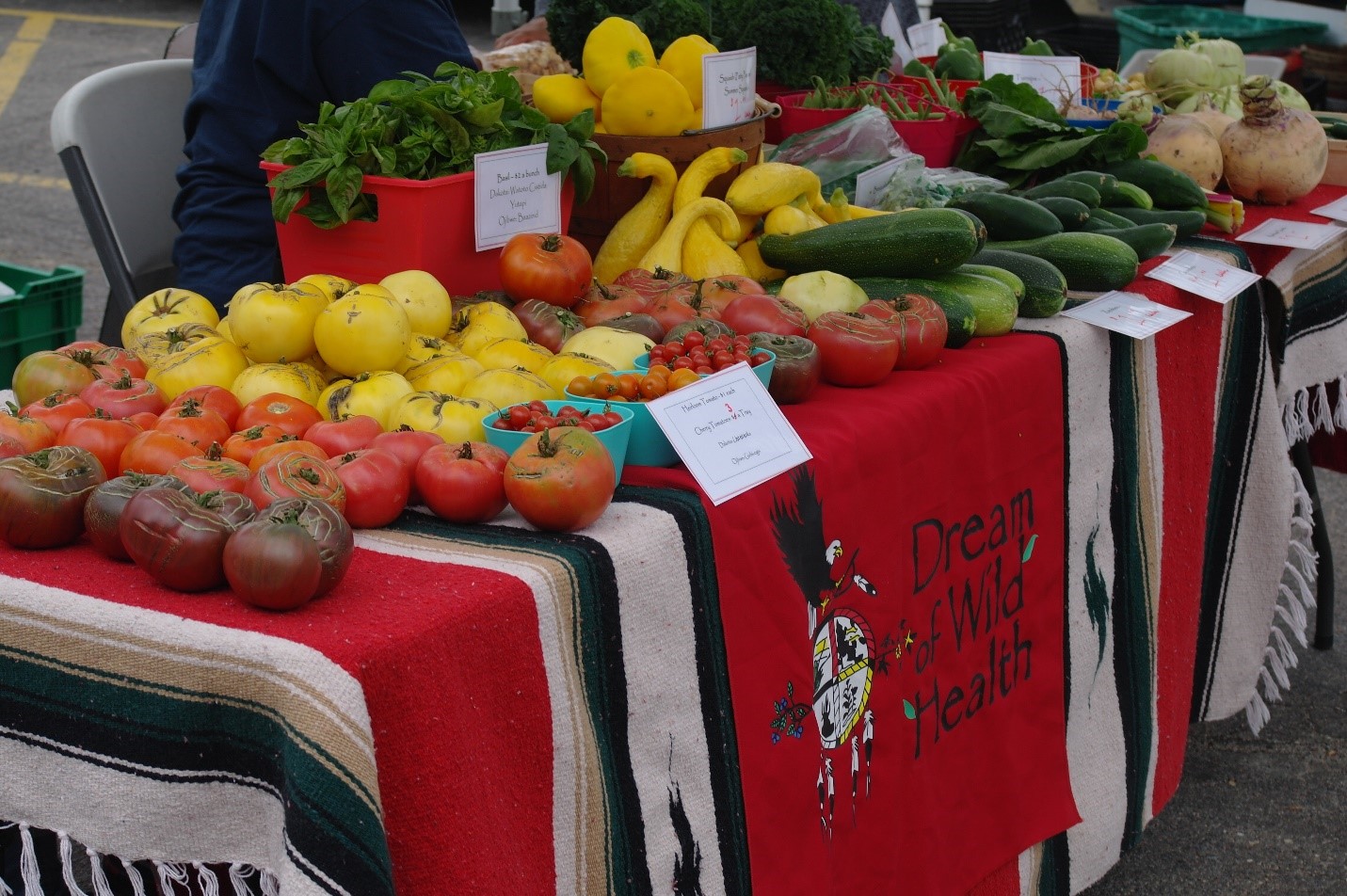 DWH farmers market booth featuring an assortment of mid-summer veggies.