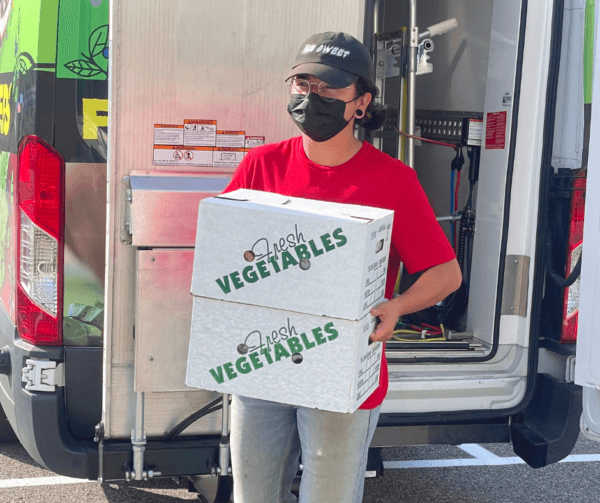 person carrying boxes of produce