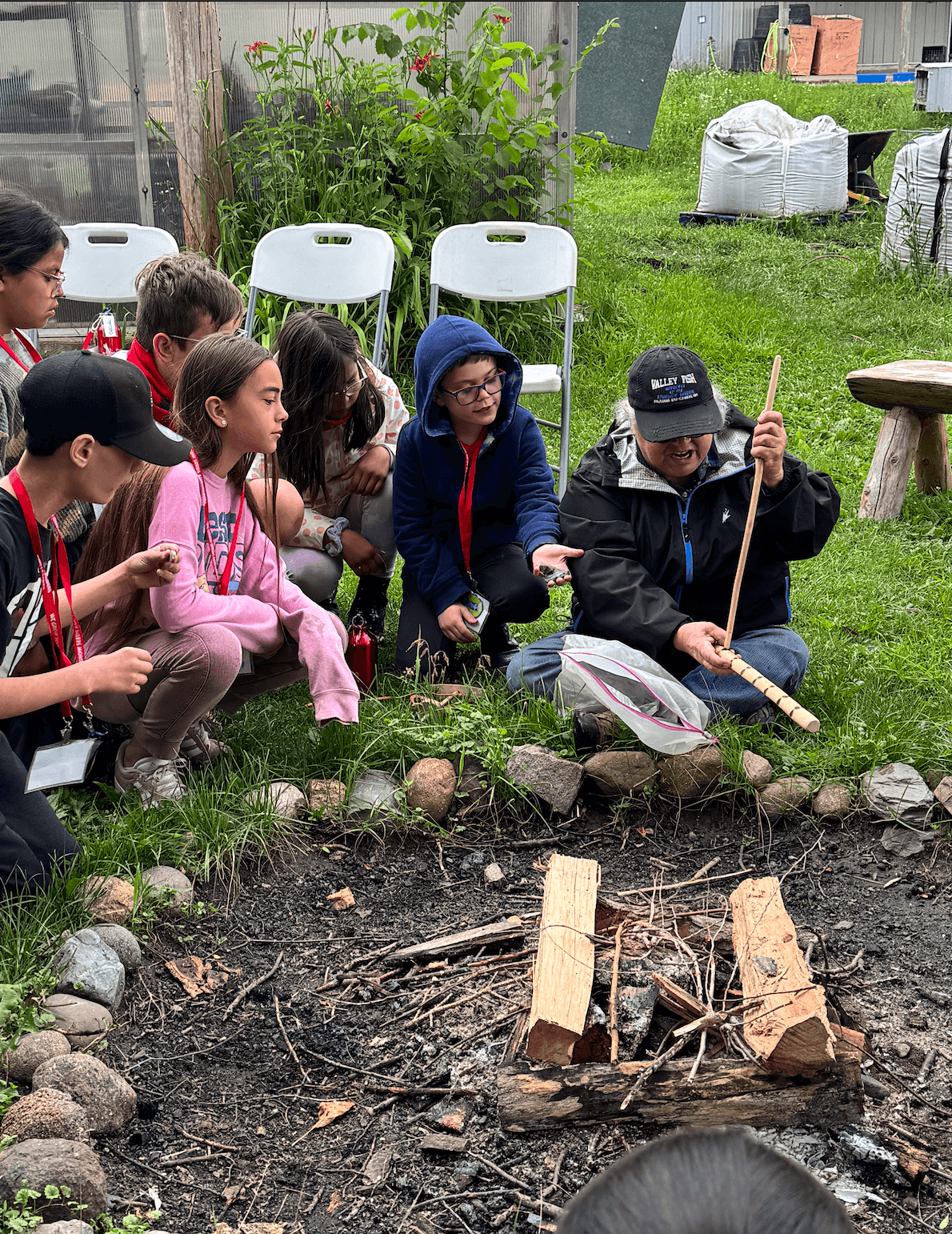 kids learning how to start a fire by hand outside